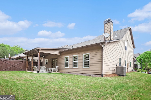 back of house with fence, central AC, ceiling fan, a patio area, and a lawn