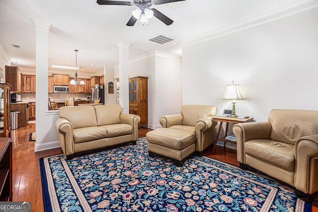 living area with visible vents, ornamental molding, ceiling fan, and hardwood / wood-style floors