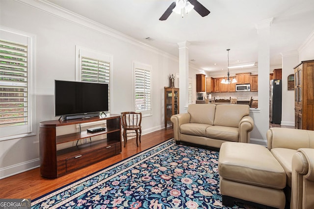 living room featuring baseboards, ornamental molding, ceiling fan, and a wealth of natural light