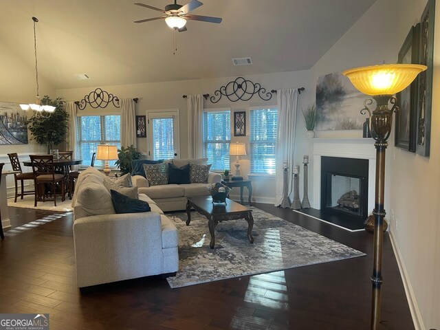 3708 Southfield Ct Unit 43A, Loganville, GA 30052 - living room with a ceiling fan, dark wood-type flooring, high vaulted ceiling, a fireplace with raised hearth, and a chandelier