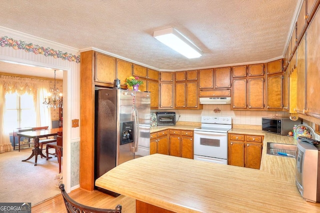 3740 Laurel Brook Way, Snellville, GA 30039 - kitchen featuring appliances with stainless steel finishes, under cabinet range hood, a chandelier, brown cabinetry, and light countertops