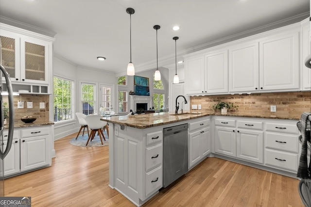 kitchen featuring stainless steel dishwasher, a sink, a peninsula, white cabinetry, and ornamental molding