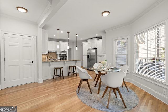 dining area with crown molding, light wood finished floors, recessed lighting, and baseboards
