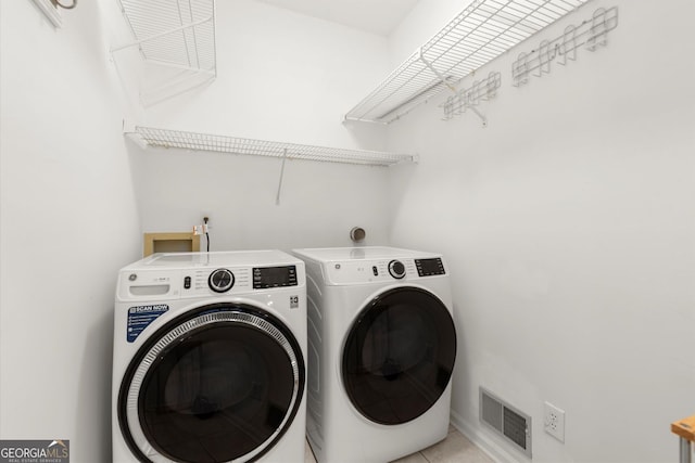 laundry room featuring independent washer and dryer and light tile patterned flooring