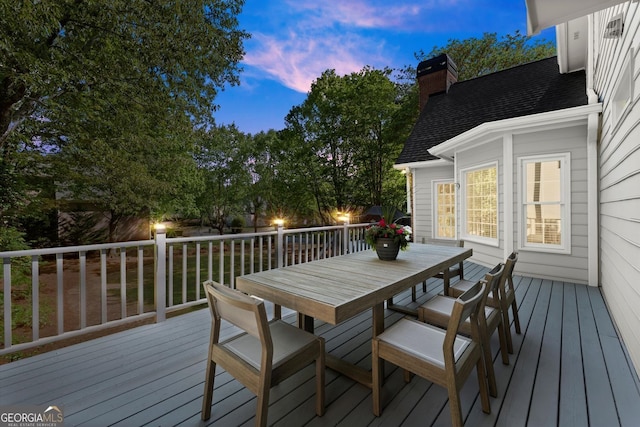 deck at dusk with outdoor dining area