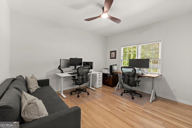 office space featuring light wood-style floors, a ceiling fan, and baseboards