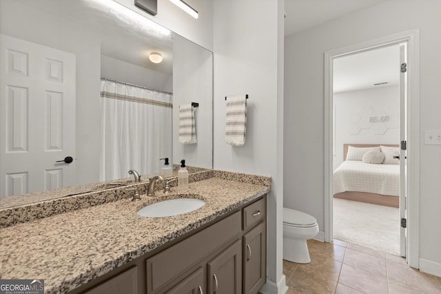 bathroom featuring toilet, vanity, tile patterned flooring, and baseboards