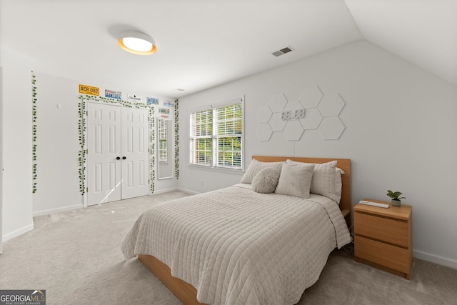 bedroom with carpet, baseboards, a closet, and vaulted ceiling