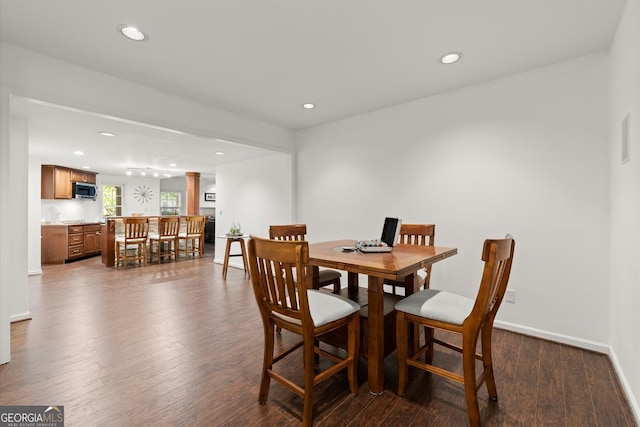 dining area featuring dark wood-style floors, recessed lighting, baseboards, and decorative columns
