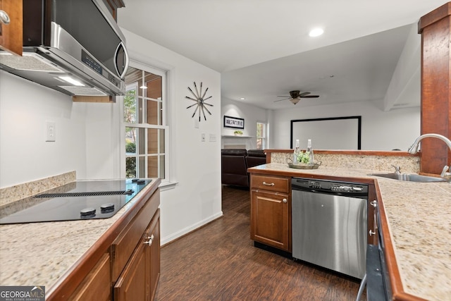 kitchen featuring appliances with stainless steel finishes, a sink, dark wood-type flooring, light countertops, and brown cabinets