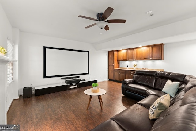 home theater room featuring a ceiling fan, wood finished floors, and baseboards