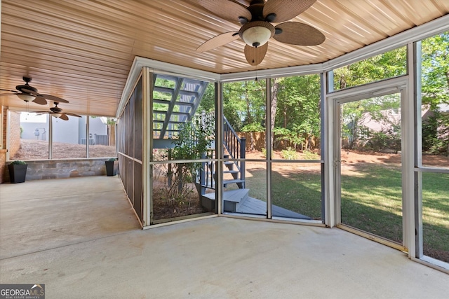 unfurnished sunroom featuring a ceiling fan