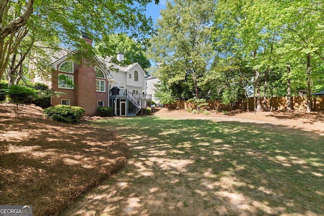 view of yard with stairway, fence, and a wooden deck