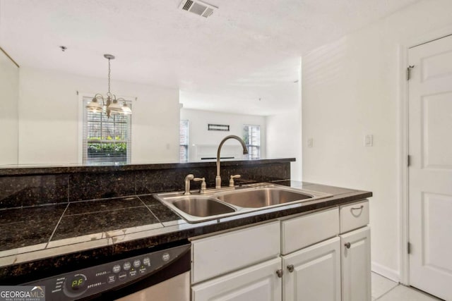 kitchen with a sink, a chandelier, dishwasher, white cabinetry, and visible vents