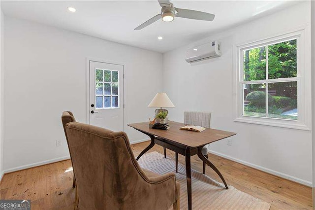 home office with a healthy amount of sunlight, a wall mounted air conditioner, light wood finished floors, and baseboards