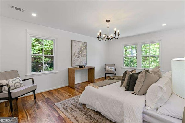 bedroom featuring wood finished floors, visible vents, recessed lighting, and a chandelier