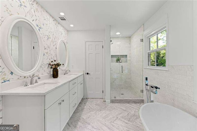 bathroom featuring a freestanding tub, visible vents, a shower stall, and a sink
