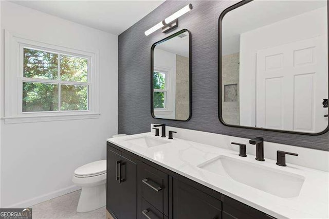 bathroom with toilet, plenty of natural light, and a sink