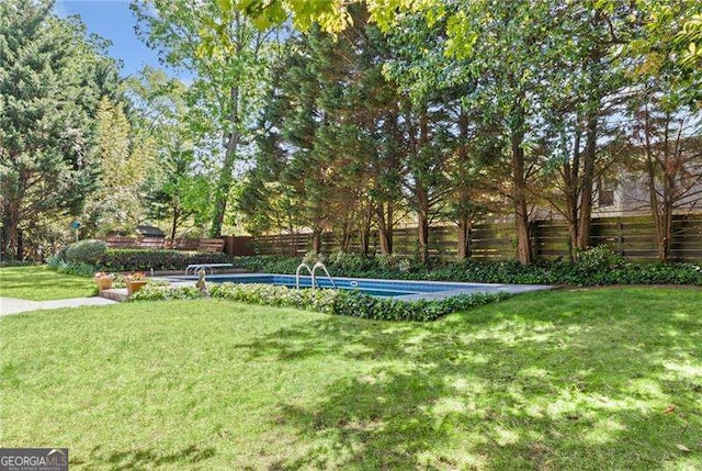 view of home's community featuring a lawn, a swimming pool, and a fenced backyard