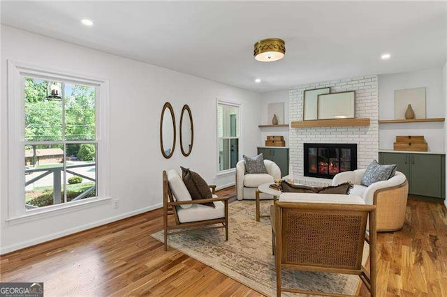 living room with baseboards, wood finished floors, a wealth of natural light, and a fireplace