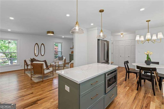 kitchen with a wealth of natural light, appliances with stainless steel finishes, and light wood-style flooring