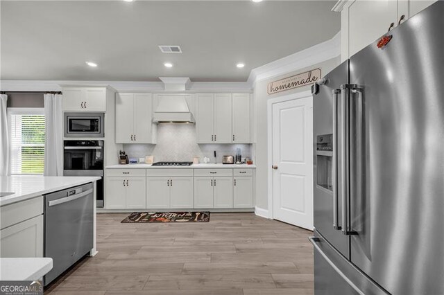 5003 Fairview Cir, Villa Rica, GA 30180 - kitchen with light wood-style floors, appliances with stainless steel finishes, light countertops, white cabinetry, and visible vents