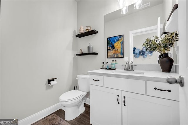 5003 Fairview Cir, Villa Rica, GA 30180 - bathroom featuring toilet, vanity, wood finished floors, and baseboards