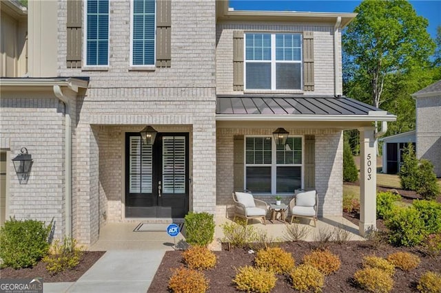 5003 Fairview Cir, Villa Rica, GA 30180 - doorway to property featuring brick siding, a porch, a standing seam roof, and metal roof