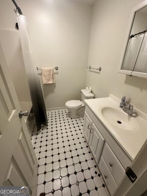 full bathroom featuring a shower with curtain, toilet, baseboards, tile patterned flooring, and vanity