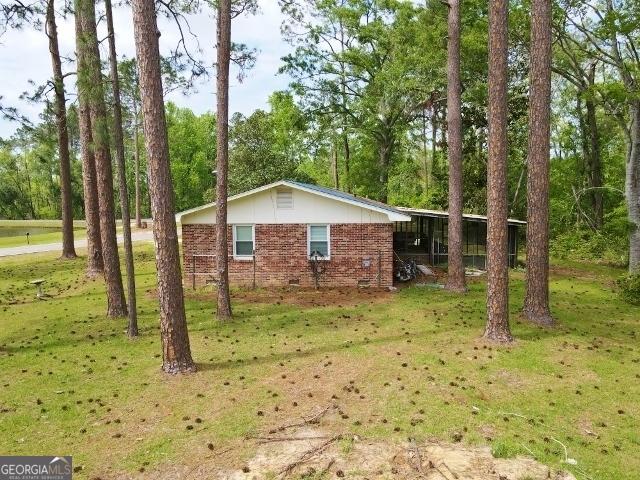 view of property exterior featuring brick siding and a lawn