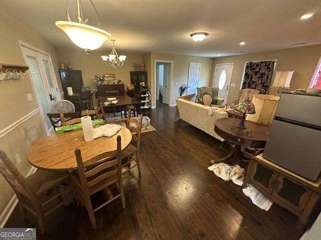 dining area with an inviting chandelier, dark wood-type flooring, and recessed lighting