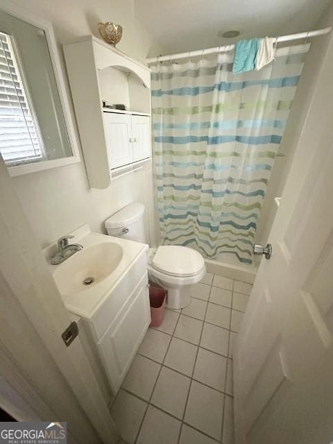 bathroom with tile patterned flooring, toilet, vanity, and curtained shower