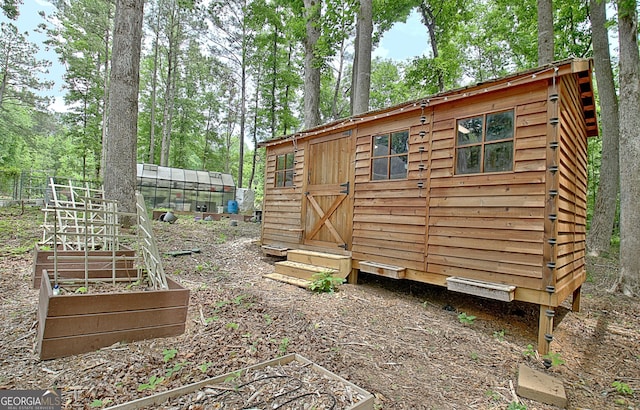 135 Adams Park Dr, Fayetteville, GA 30214 - view of outbuilding with an outbuilding, a garden, and view of wooded area