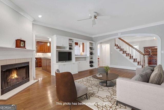 1020 Riverside Rd, Roswell, GA 30076 - living room with ornamental molding, arched walkways, ceiling fan, and light wood-style flooring
