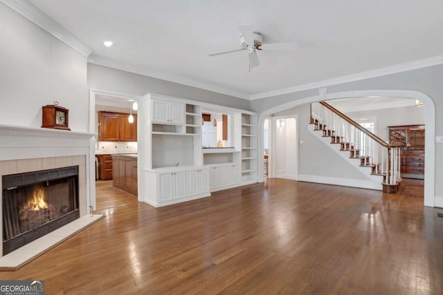 1020 Riverside Rd, Roswell, GA 30076 - unfurnished living room featuring stairway, arched walkways, ornamental molding, a tiled fireplace, and a ceiling fan