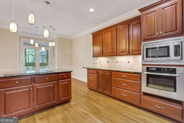 1020 Riverside Rd, Roswell, GA 30076 - kitchen featuring light wood-style flooring, dark stone counters, appliances with stainless steel finishes, pendant lighting, and crown molding