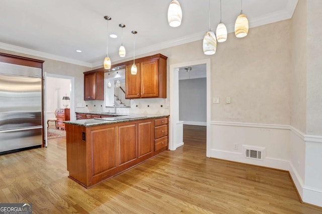 1020 Riverside Rd, Roswell, GA 30076 - kitchen with pendant lighting, built in fridge, light wood finished floors, a peninsula, and brown cabinetry