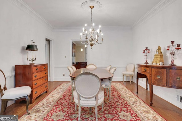 1020 Riverside Rd, Roswell, GA 30076 - dining space with wainscoting, wood finished floors, an inviting chandelier, and crown molding