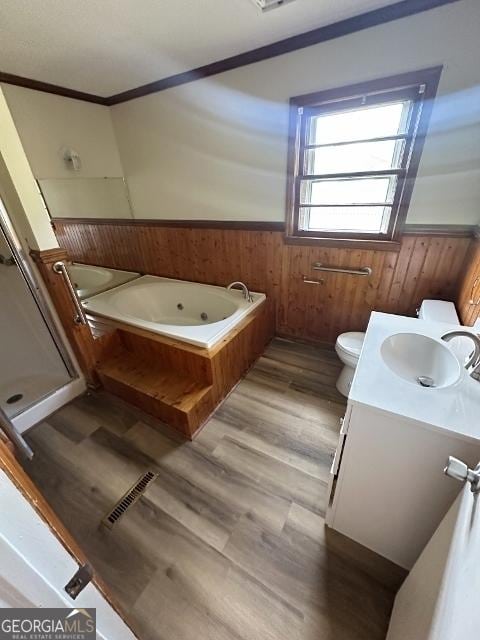 bathroom featuring crown molding, wainscoting, vanity, a jetted tub, and visible vents