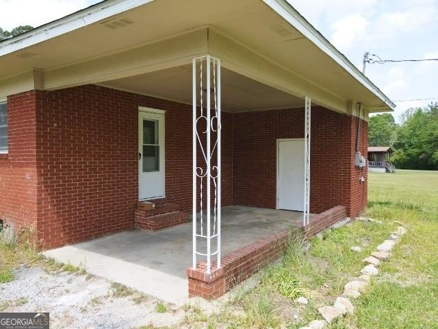 view of side of home featuring brick siding and entry steps
