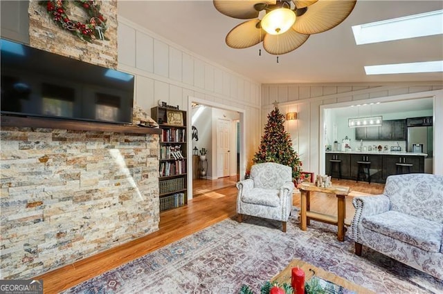 70 Denny Ridge Rd, Jasper, GA 30143 - living room with a decorative wall, a ceiling fan, wood finished floors, and a skylight