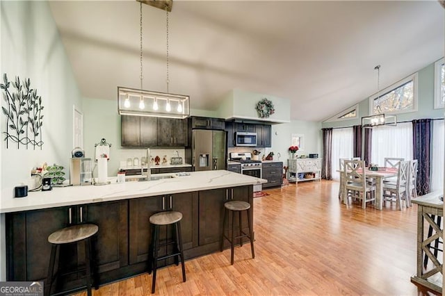 70 Denny Ridge Rd, Jasper, GA 30143 - kitchen featuring stainless steel appliances, a breakfast bar, a sink, light wood-style flooring, and high vaulted ceiling