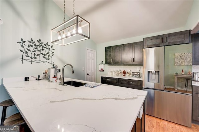 70 Denny Ridge Rd, Jasper, GA 30143 - kitchen featuring a kitchen breakfast bar, tasteful backsplash, a sink, stainless steel fridge, and light stone countertops