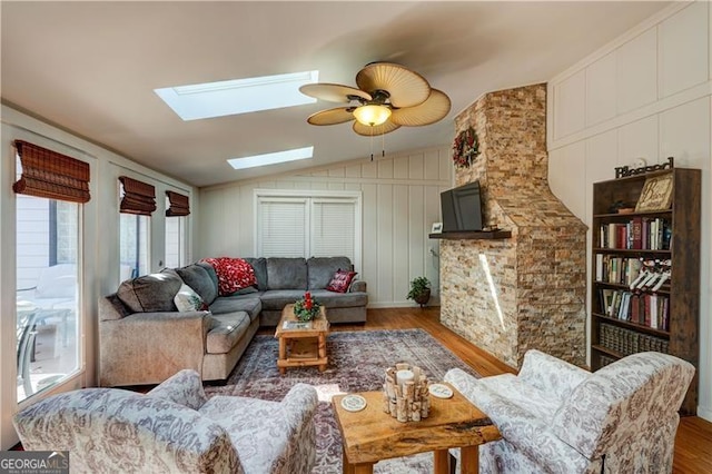 70 Denny Ridge Rd, Jasper, GA 30143 - living area featuring a ceiling fan, wood finished floors, lofted ceiling with skylight, and a decorative wall