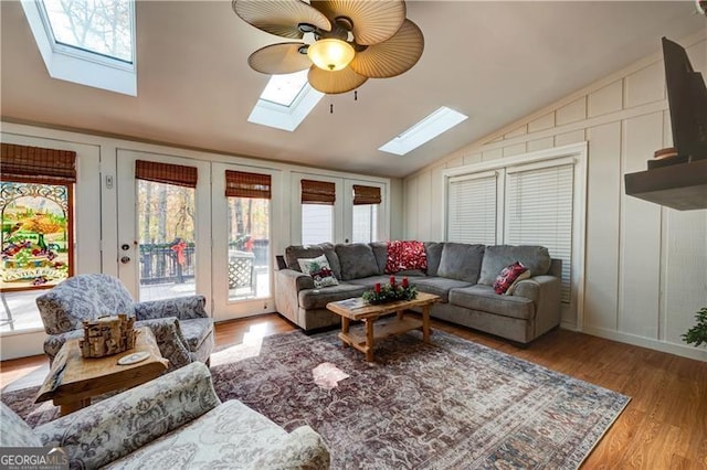 70 Denny Ridge Rd, Jasper, GA 30143 - living room featuring a ceiling fan, a decorative wall, vaulted ceiling with skylight, and wood finished floors