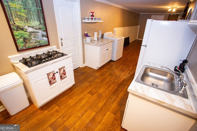 6147 Pritchett Dr, Powder Springs, GA 30127 - kitchen featuring washer / dryer, black gas cooktop, a sink, wood finished floors, and ornamental molding