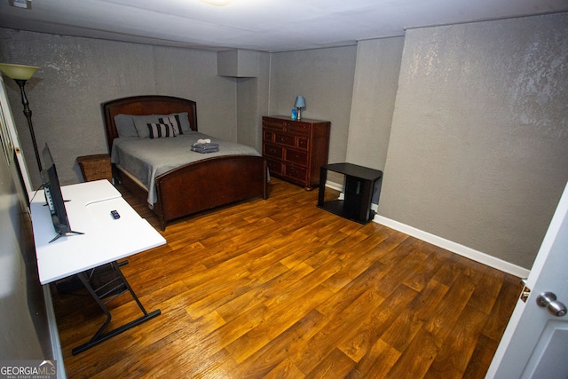 6147 Pritchett Dr, Powder Springs, GA 30127 - bedroom featuring wood finished floors, a textured wall, and baseboards