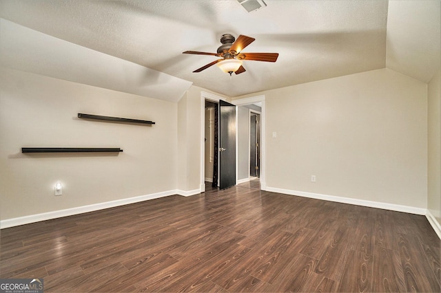 interior space featuring dark wood-style flooring, baseboards, visible vents, lofted ceiling, and ceiling fan