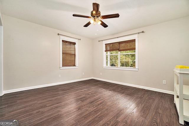 empty room featuring visible vents, baseboards, ceiling fan, and dark wood finished floors