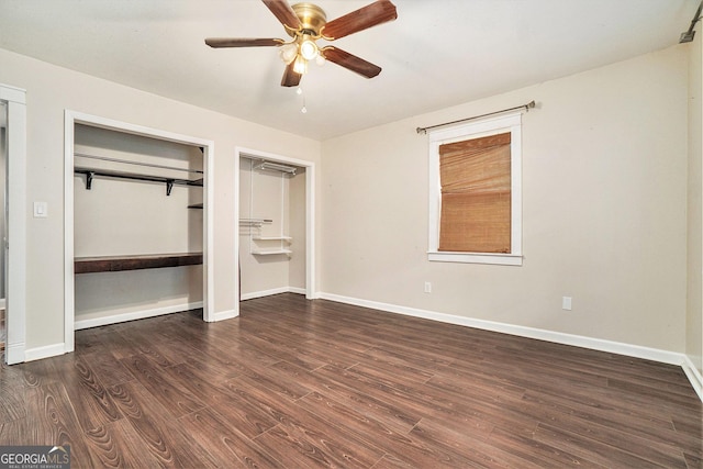 unfurnished bedroom with a ceiling fan, baseboards, and dark wood-type flooring